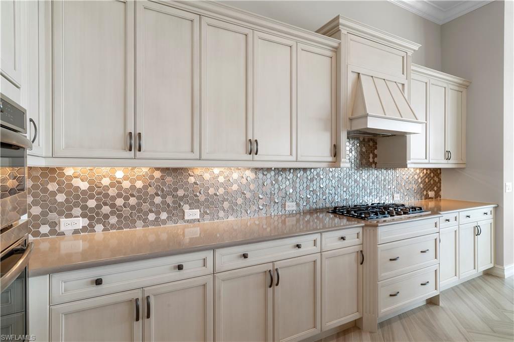 6254 Lightbourn Way Naples, FL 34113 - Photo 19 of 34 a kitchen with granite countertop white cabinets and stainless steel appliances