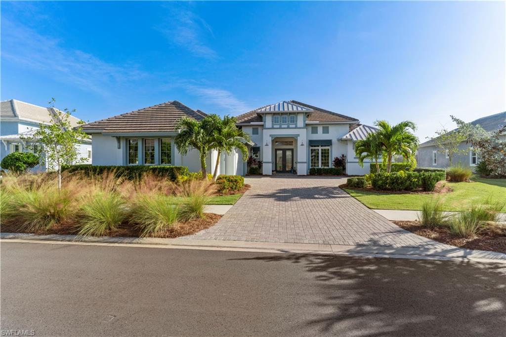 6254 Lightbourn Way Naples, FL 34113 - Photo 2 of 34 a front view of a house with a yard and potted plants