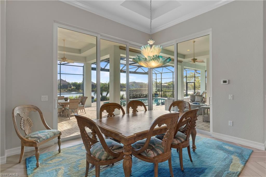 6254 Lightbourn Way Naples, FL 34113 - Photo 21 of 34 a view of a dining room with furniture wooden floor and chandelier