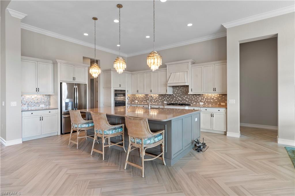 6254 Lightbourn Way Naples, FL 34113 - Photo 26 of 34 a kitchen with a dining table chairs and cabinets