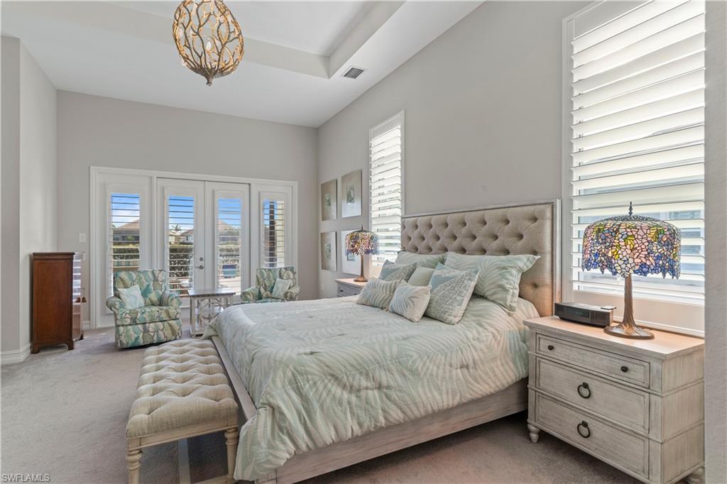 6254 Lightbourn Way Naples, FL 34113 - Photo 28 of 34 a bedroom with a bed and a chandelier