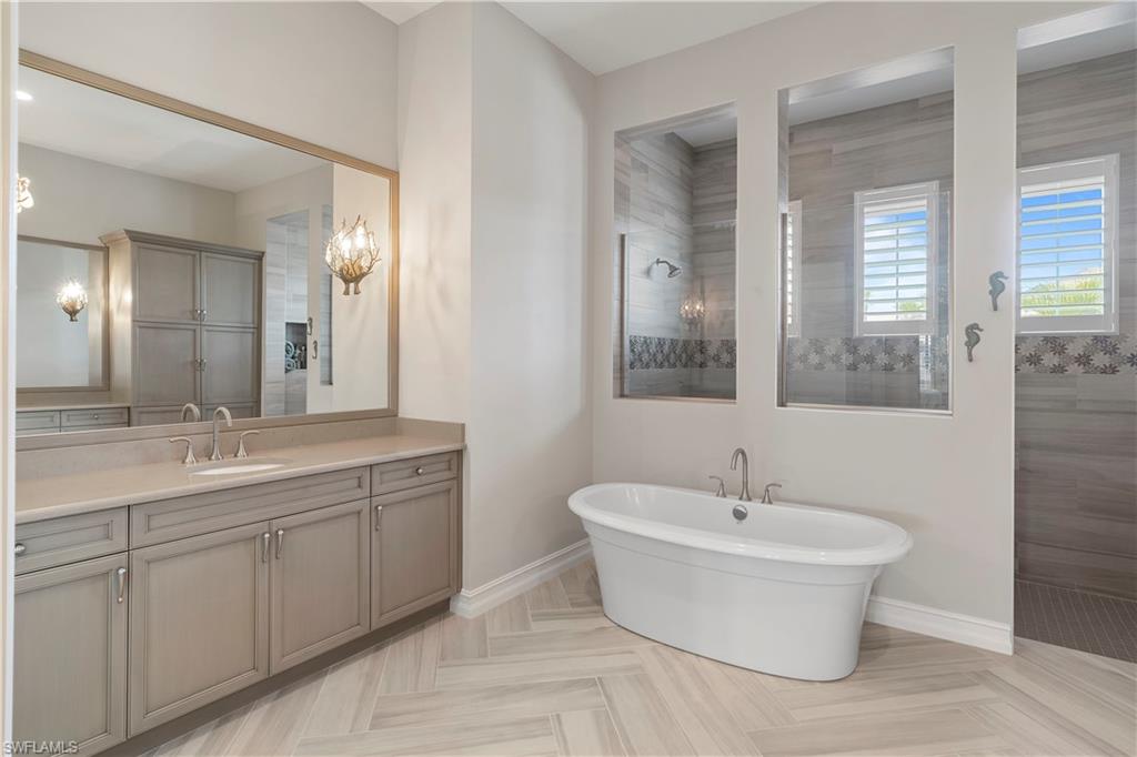 6254 Lightbourn Way Naples, FL 34113 - Photo 30 of 34 a bathroom with a white tub sink and mirror