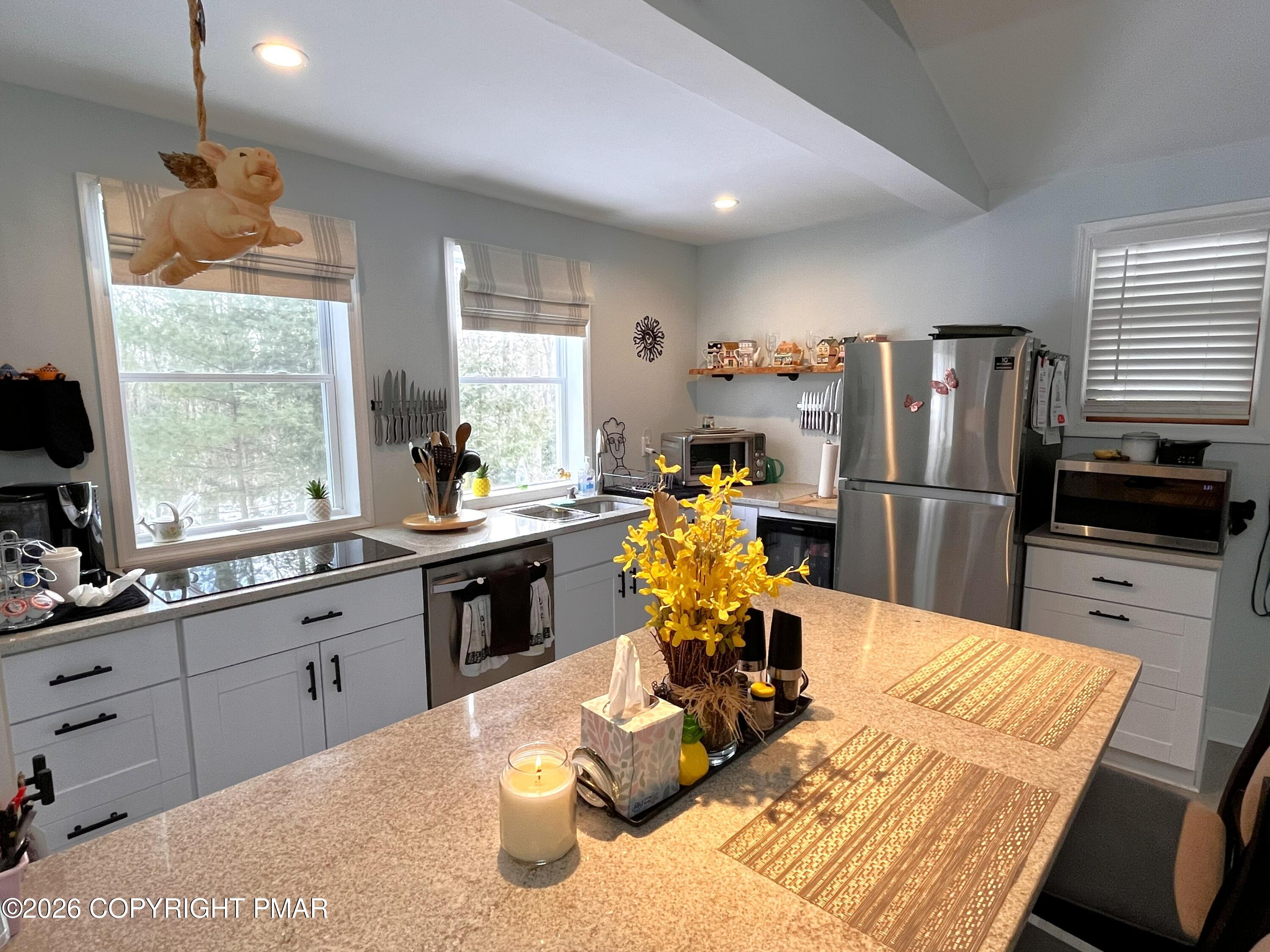 29 Hopi Road Jim Thorpe, PA 18229 - Photo 14 of 44 a kitchen with stainless steel appliances kitchen island granite countertop a refrigerator a sink dishwasher a stove and a dining table with wooden floor