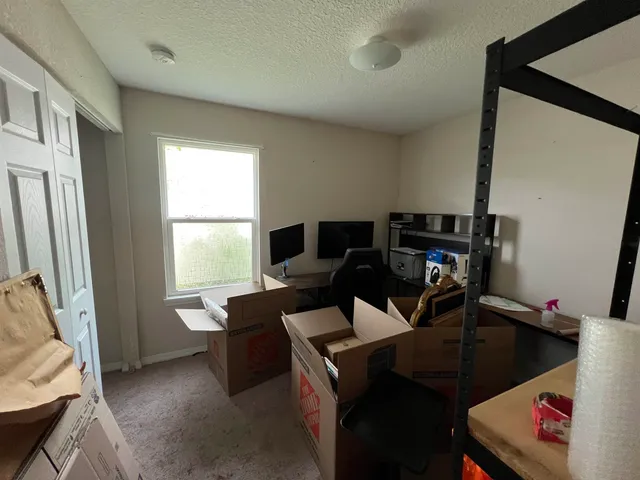 a view of a workspace with furniture and a window