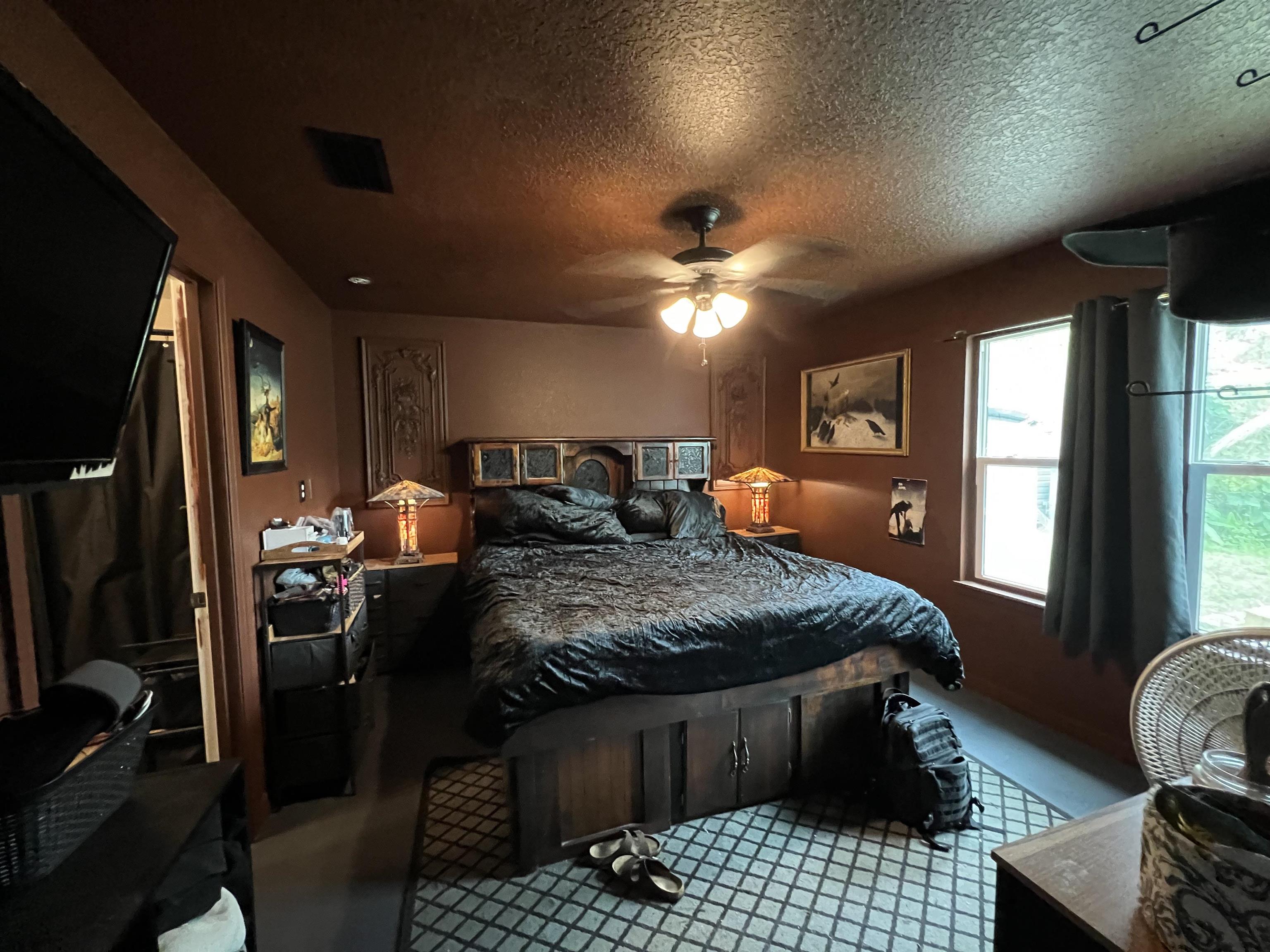 921 Avery Street St. Augustine, FL 32084 - Photo 18 of 29 a bedroom with a bed a chandelier and a flat screen television