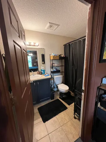 a bathroom with a sink a toilet a mirror and shower