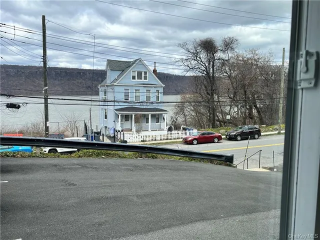 a view of a dry yard with trees in the background