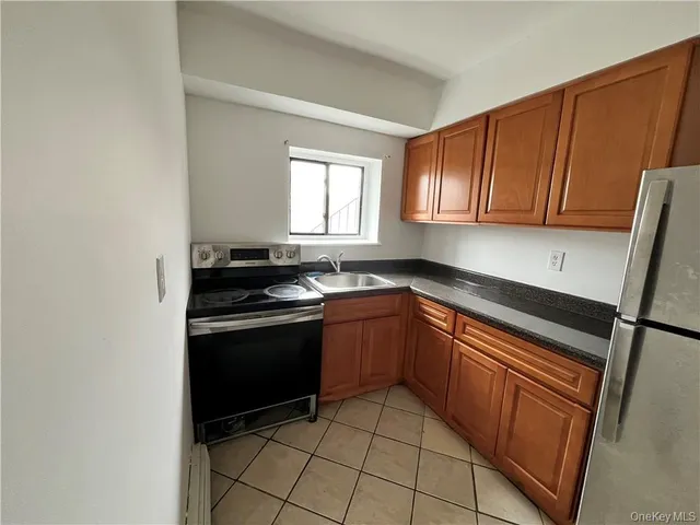 a kitchen with granite countertop wooden cabinets and a stove top oven
