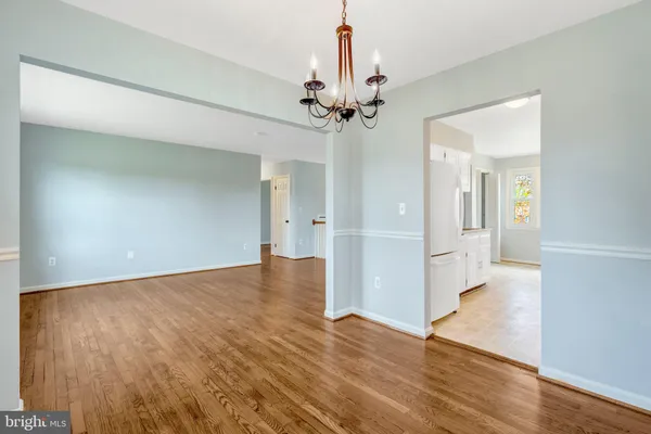 a large kitchen with stainless steel appliances lots of white cabinets