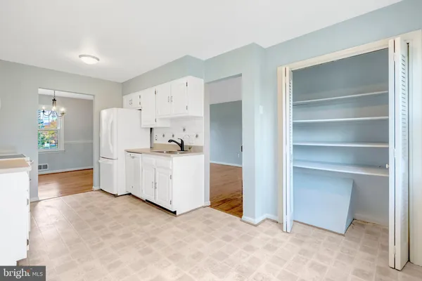 a kitchen with granite countertop white cabinets and refrigerator