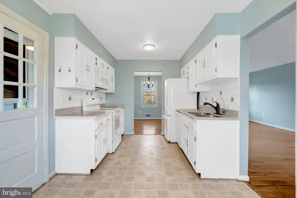 a kitchen with white cabinets and white appliances
