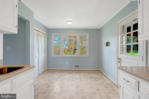 a kitchen with stainless steel appliances granite countertop white cabinets and window