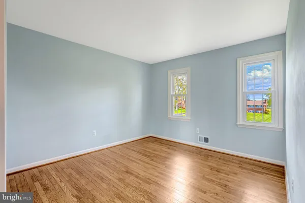 an empty room with window and wooden floor