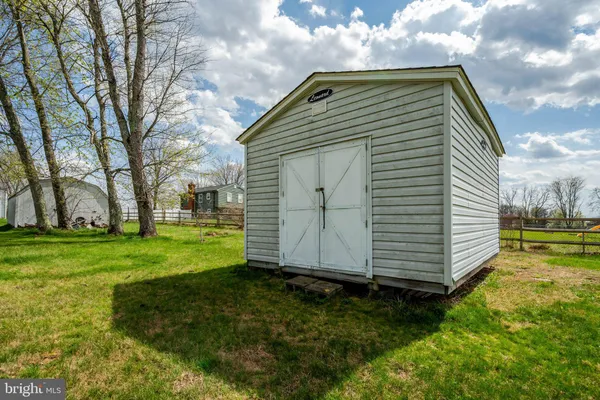 a view of a house with a big yard plants and large trees