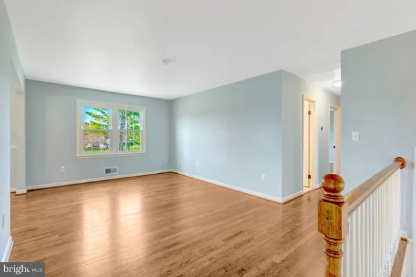 a view of empty room with wooden floor