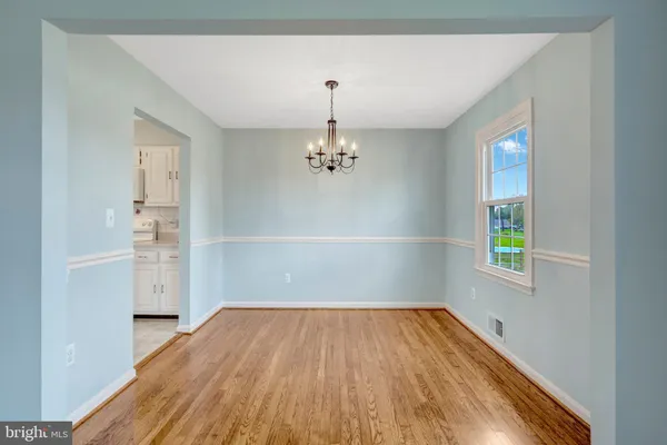 a view of empty room with window and wooden floor