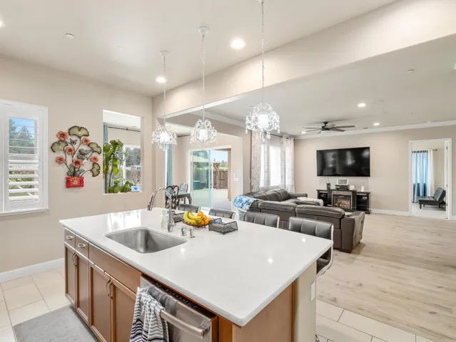 a kitchen with stainless steel appliances kitchen island granite countertop a refrigerator and a stove top oven