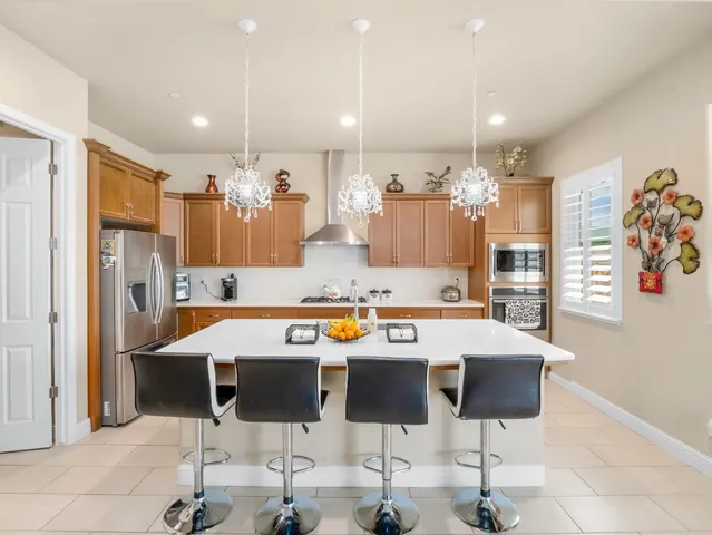 a kitchen with stainless steel appliances granite countertop a stove a sink a microwave a refrigerator and cabinets
