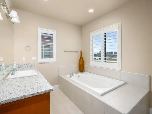 a bathroom with a granite countertop sink a toilet and shower