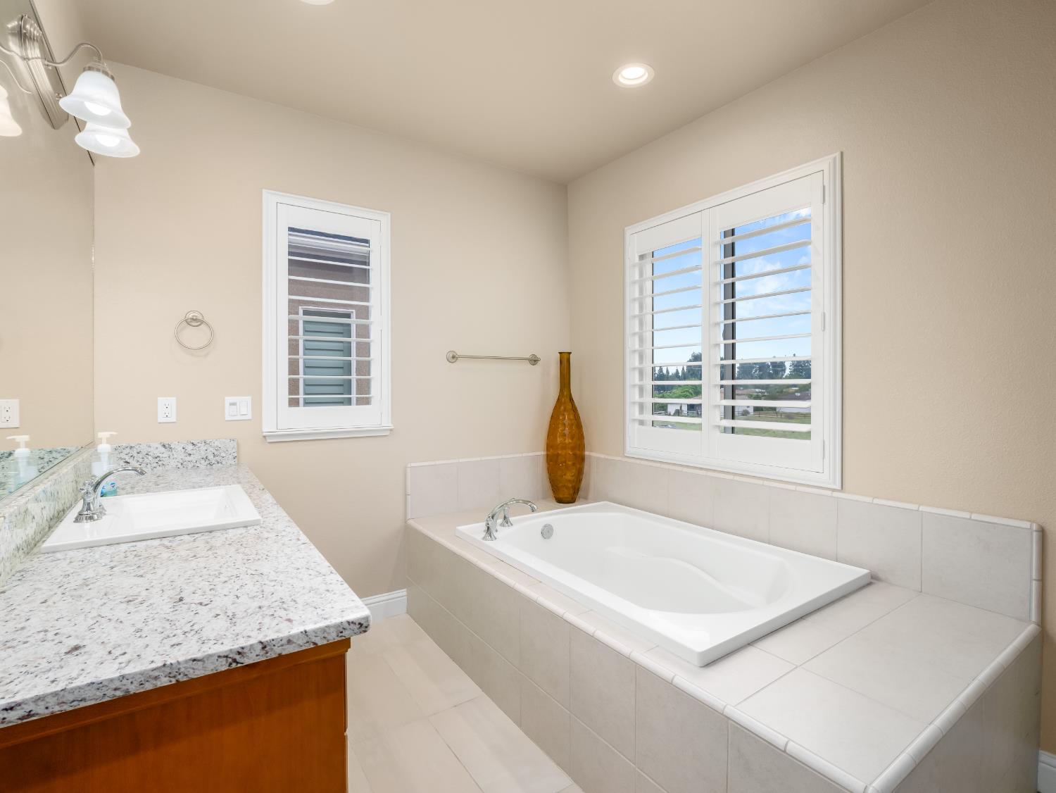2127 Chennault Avenue Clovis, CA 93611 - Photo 31 of 49 a bathroom with a tub sink and mirror