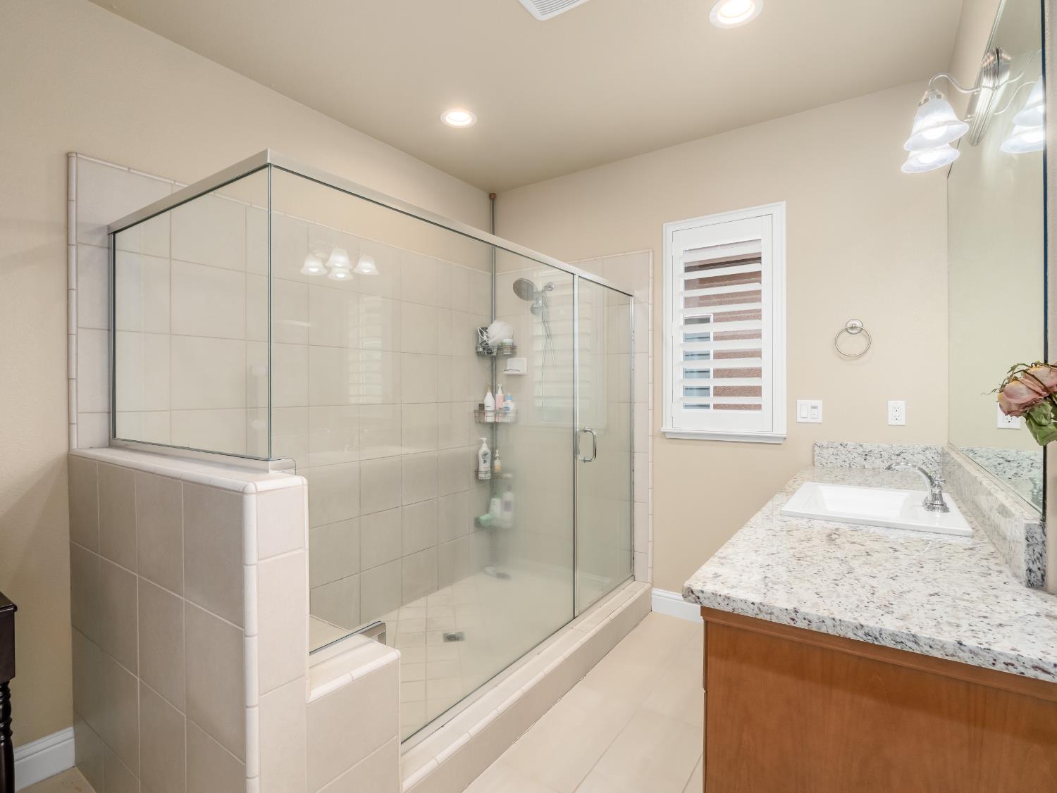 2127 Chennault Avenue Clovis, CA 93611 - Photo 32 of 49 a bathroom with a granite countertop sink a toilet and shower