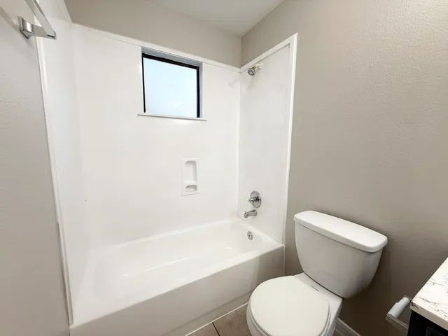 a white toilet sitting next to a bath tub