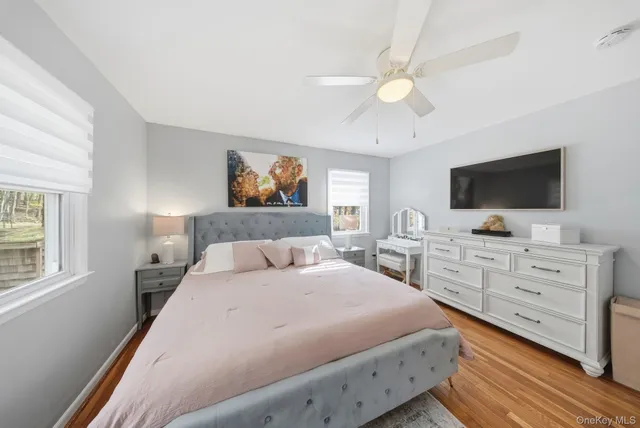 a bedroom with a large bed and a flat tv screen on dresser