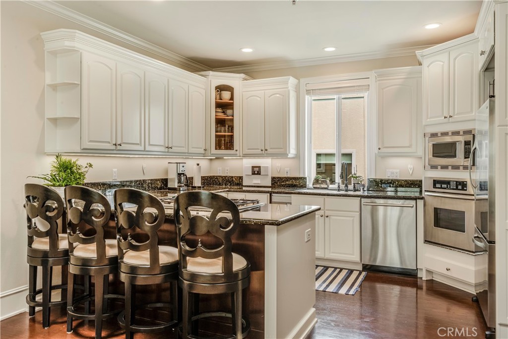 520 Esplanade, Unit D Redondo Beach, CA 90277 - Photo 6 of 24 a kitchen with a table chairs microwave and cabinets