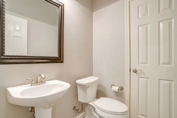 a bathroom with a sink a toilet and mirror