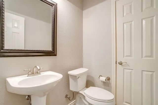 a bathroom with a sink a toilet and mirror