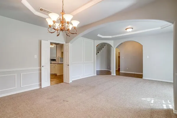 a view of a livingroom with a chandelier fan and windows