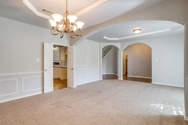 a view of a livingroom with a chandelier fan and windows