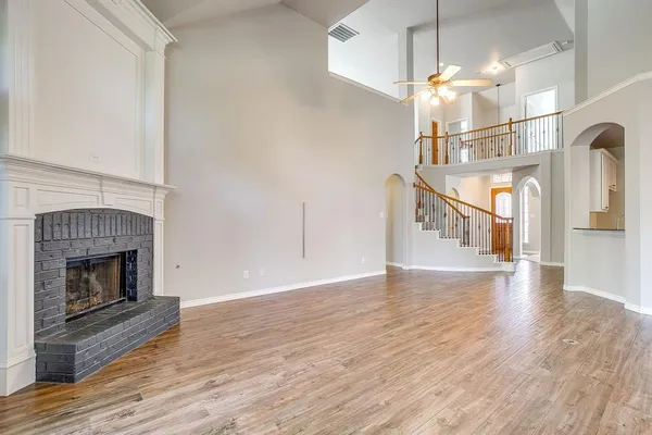 a view of a livingroom with wooden floor and a fireplace