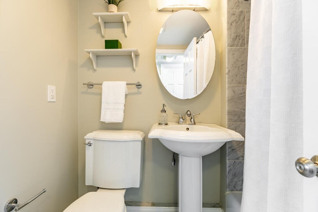 345 Harvard Street, Unit 3C Cambridge, MA 02138 - Photo 13 of 21 a bathroom with a toilet sink and mirror