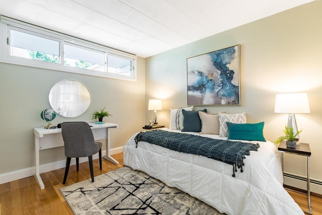 345 Harvard Street, Unit 3C Cambridge, MA 02138 - Photo 15 of 21 a bedroom with a bed and a chandelier