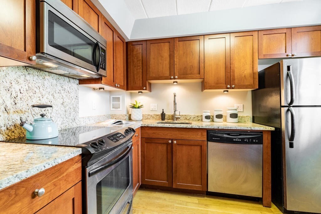 345 Harvard Street, Unit 3C Cambridge, MA 02138 - Photo 8 of 21 a kitchen with stainless steel appliances granite countertop a stove a sink and a microwave