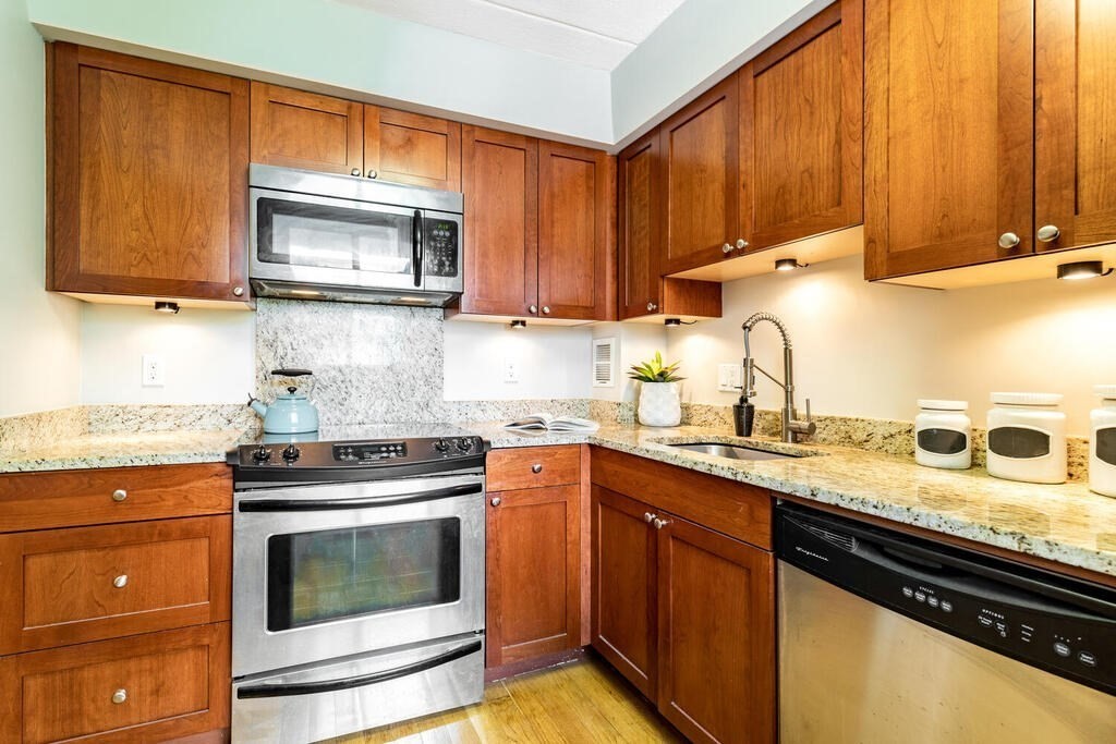 345 Harvard Street, Unit 3C Cambridge, MA 02138 - Photo 9 of 21 a kitchen with stainless steel appliances granite countertop a sink stove and microwave