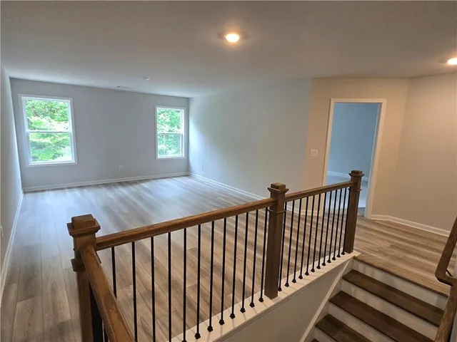 a view of a hallway with wooden floor and stairs