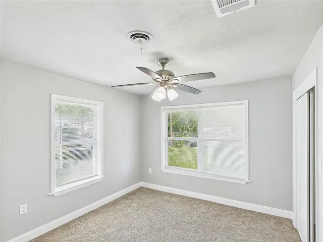 a view of a livingroom with a window and a ceiling fan