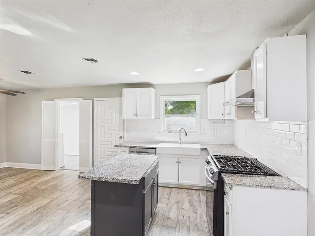 a kitchen with a sink stove and cabinets