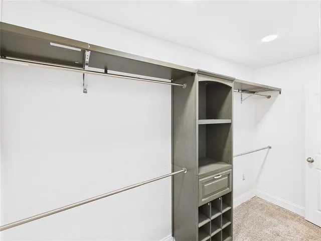 a view of walk in closet with empty racks