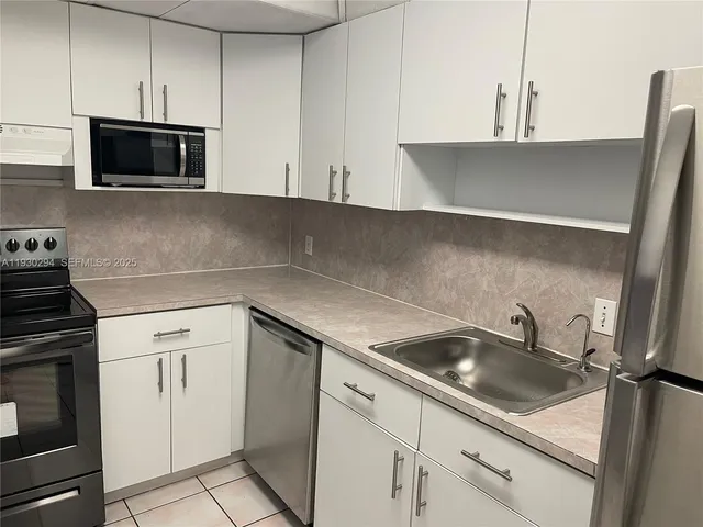 a kitchen with a sink a stove and cabinets