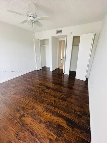 a view of a room with wooden floor and cabinet