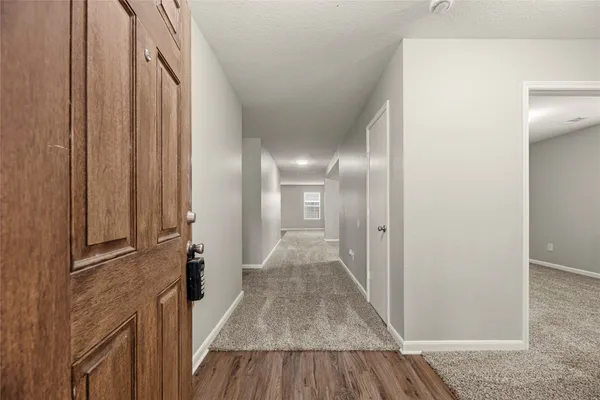 a view of a hallway with wooden floor