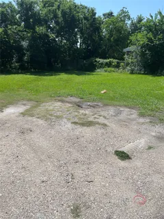 a view of a field with trees in the background