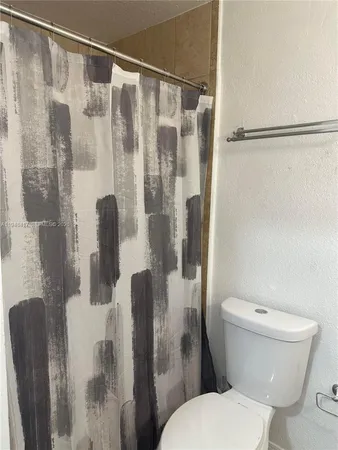 a white toilet sitting next to a bathroom shower