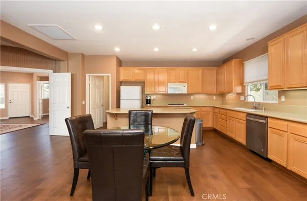 a kitchen with a table chairs sink microwave and cabinets