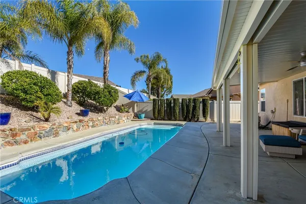 a swimming pool with outdoor seating and a potted plant