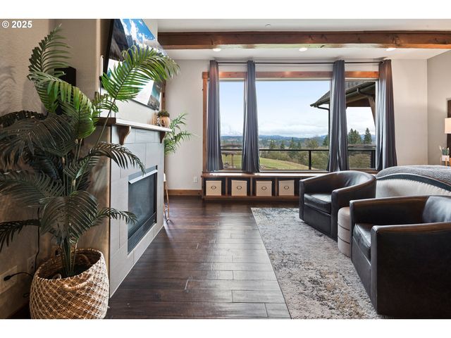 a living room with furniture floor to ceiling window and a potted plant