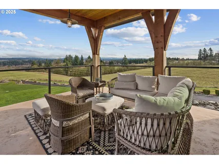 a view of a patio with couches potted plants and a big lake
